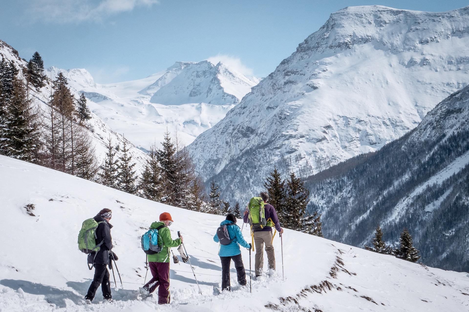 Group of friends snow shoe hiking across snowy mountain in Val Cenis ski resort
